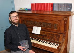 Kantor mit Probegesangbuch am Klavier