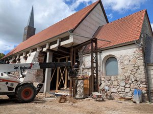 An die Kirchenseiten werden Säulen gebaut; es sind mit Beton ummantelte Stahlstäbe.  