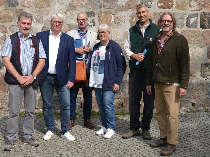 Eine Gruppe von Menschen steht vor einer Kirche.