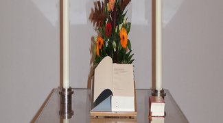 Altar mit Blumenschmuck, Kerzen und Bibel