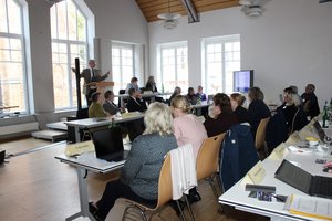 Viele Menschen sitzen in einem Raum.