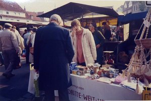 Eine Frau steht 1983 hinter einem Stand mit Weltladen-Produkten auf dem Markt in Rendsburg