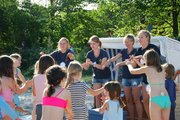 Eine Gruppe Kinder singt und gestikuliert unter Anleitung