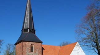 Kirche in Jevenstedt, weißer Bau an Turm aus rotem Stein
