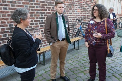 Zwei Frauen und ein Mann im Gespräch vor der Kirche St. Nicolai
