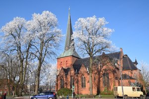 Nortorfer Kirche hinter winterlich-weißen Bäumen im Sonnenschein
