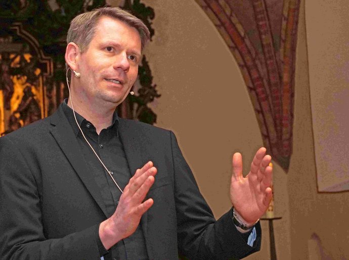 Der Kandidat für das Propstamt Dennis Pistol stellte sich nach dem Gottesdienst den Fragen der Gäste. Pastor vor Altar