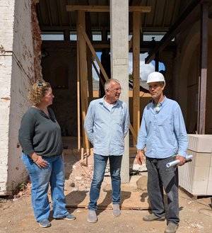Pastorin Diana Krückmann, Rohbauunternehmer Hauke Domeyer und Architekt Filip Fröhler (v. links) betrachten die Baustelle der Kirche Hademarschen. 