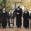 Sechs Menschen in geistlicher Kleidung mit Atemschutz