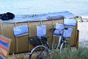 Ein Fahrrad lehnt an einem Strandkorb, der mit Plakaten beklebt ist