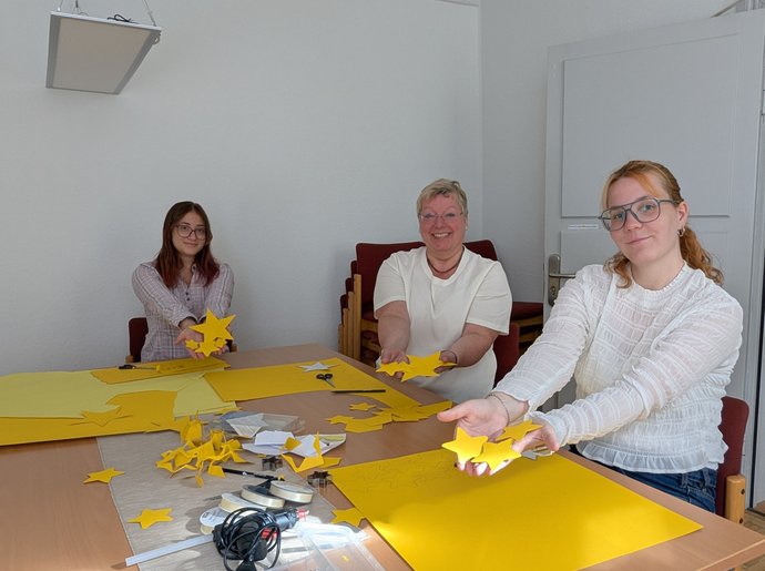 Svenja Horeis (FSJlerin), Barbara Leicht und Emma Wiese (beide Theologische Bildung) (von links) stellen für die „Lange Nacht des Miteinanders“ eine Sternengirlande her.