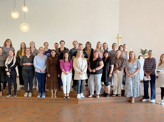 Menschen stehen in einer Kirche. 