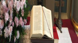 Altar mit Blumenschmuck, Kerzen und Bibel