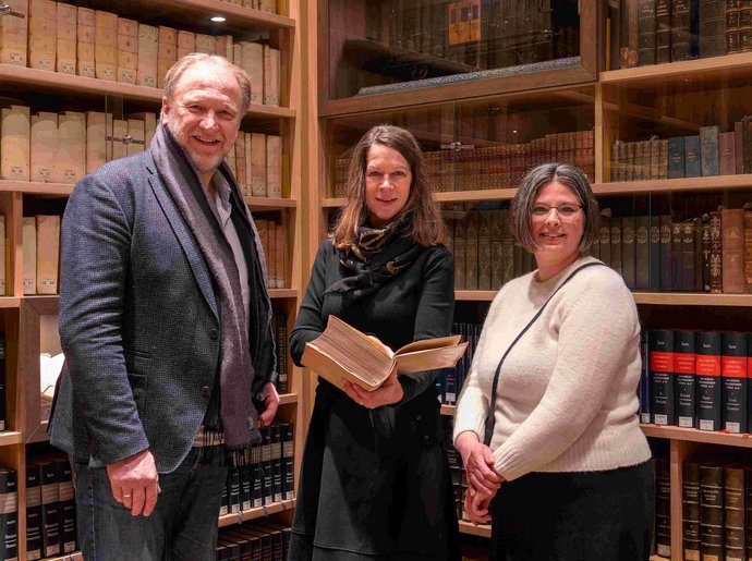 Beeindruckt von der Gudeschen Bibliothek: Pastor Rainer Karstens (Kirchengemeinde Rendsburg), Dr. Sonja Grund (Mitte) und Dr. Maike Manske (beide Schleswig-Holsteinische Landesbibliothek). Drei Leute vor einem Bibliotheksregal