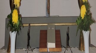 Altar mit Blumenschmuck, Kerzen und Bibel