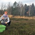 Junger Mensch neben grüner Kiste auf Wiese